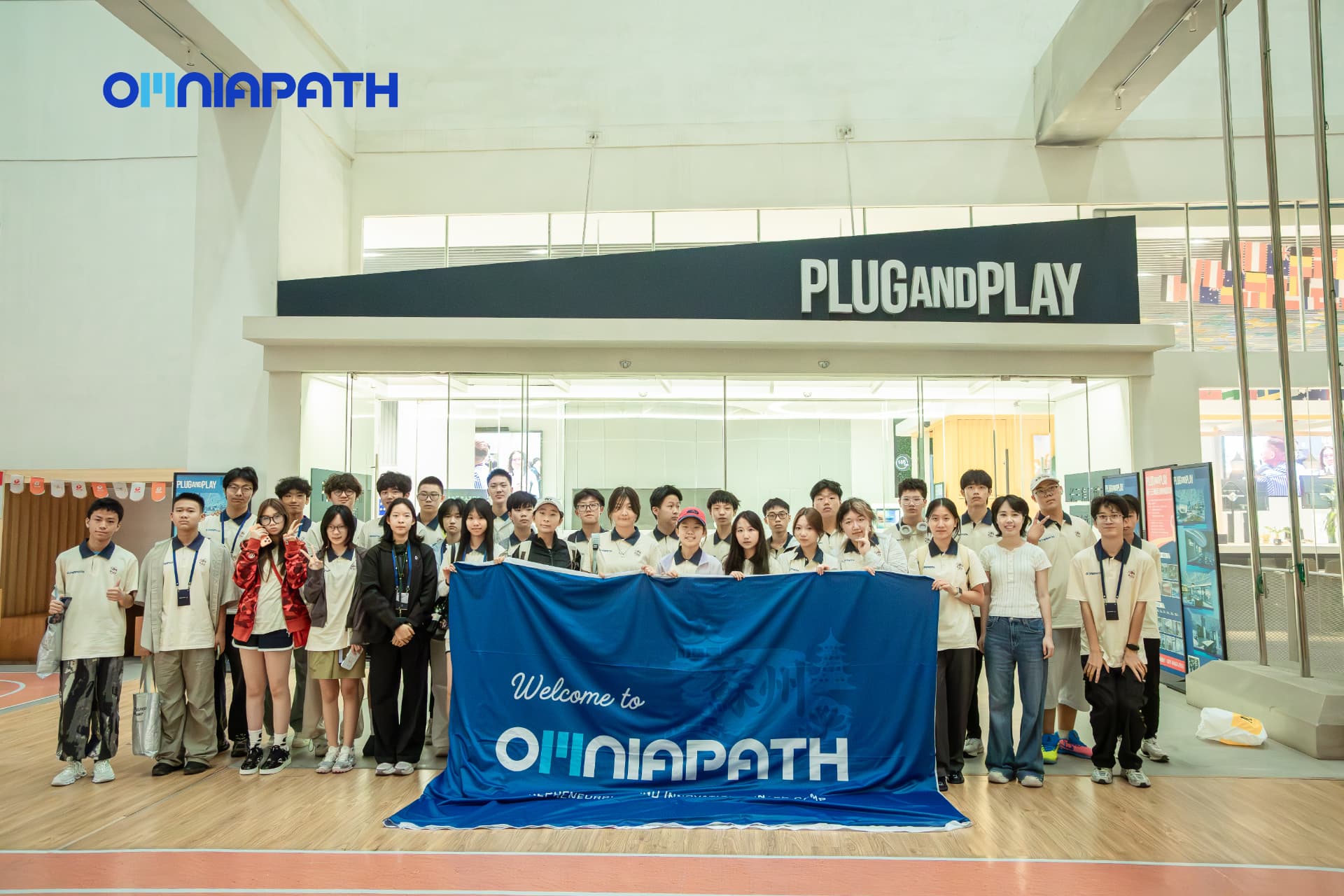OMNIAPATH cohort holding their banner at Plug and Play