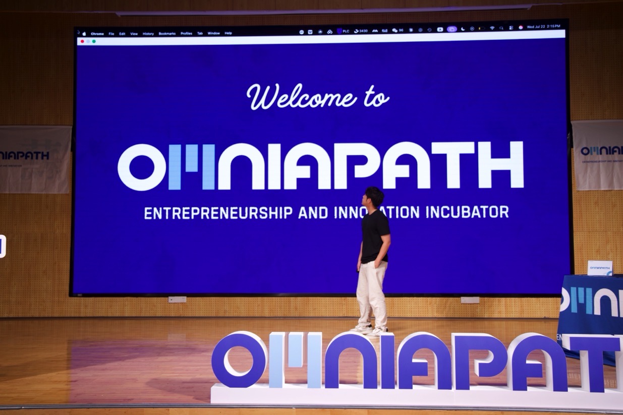 OMNIAPATH founder on stage in front of the Entrepreneurship and Innovation Incubator screen