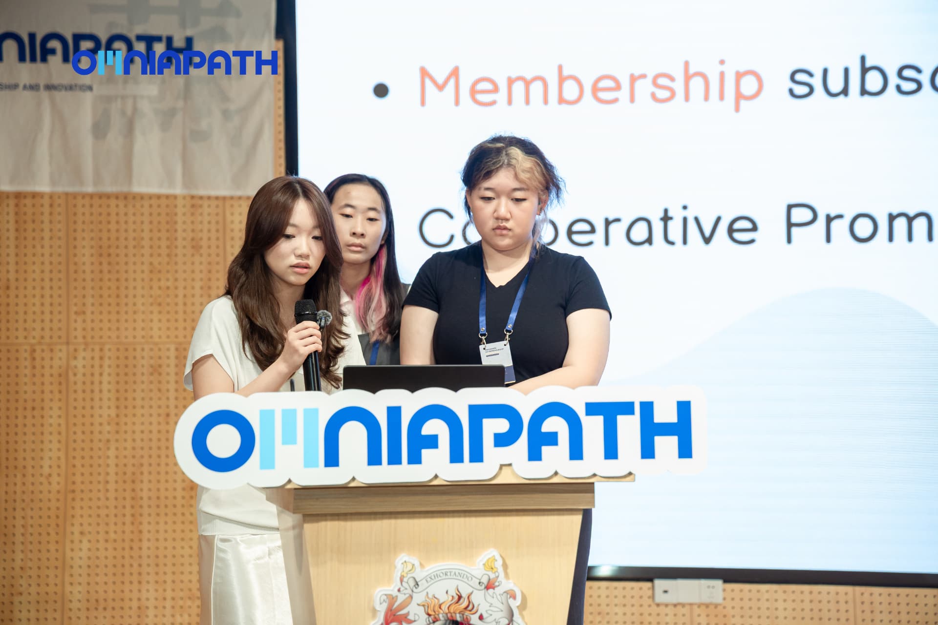An OMNIAPATH student presenting a live venture pitch at the podium